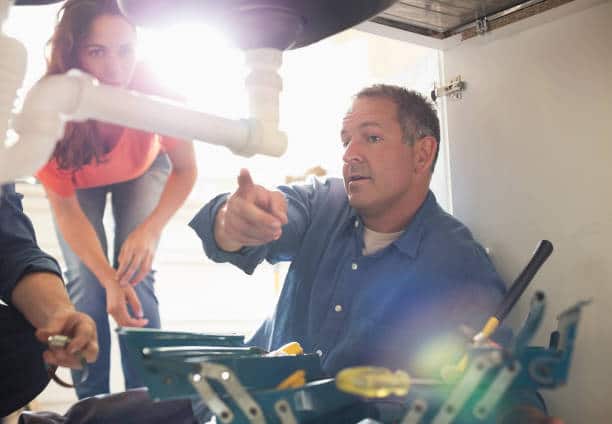 A plumber instructing the women about the plumbing system